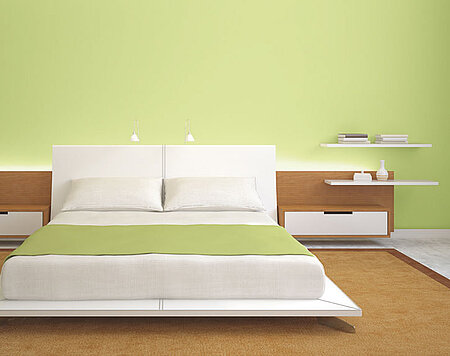 Bett mit grüner Wand
