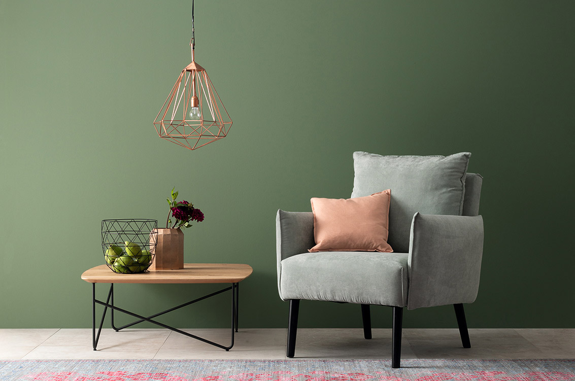 Wohnzimmer mit grünem Sessel, Designfarbe Piniengrün Wohnzimmer mit grünem Sessel, Designfarbe Piniengrün